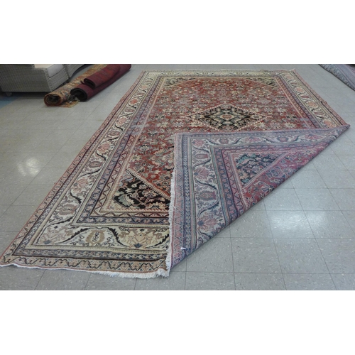 138 - A large eastern red ground rug, 515 x 319cms