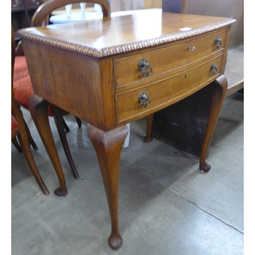 148 - An Queen Anne style oak two drawer side table