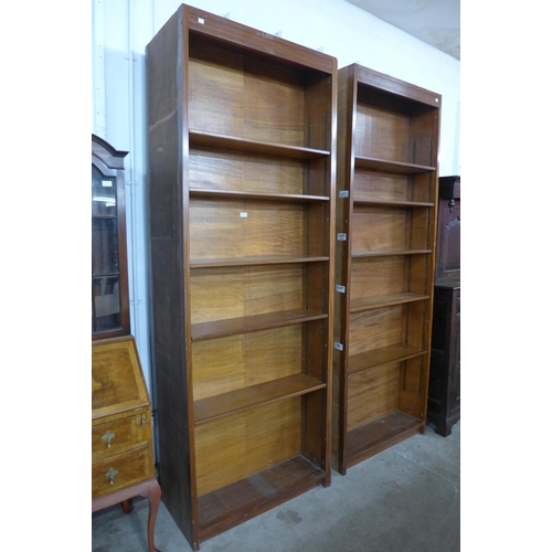 169 - A pair of tall teak double sided open bookcases