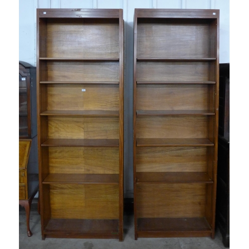 169 - A pair of tall teak double sided open bookcases