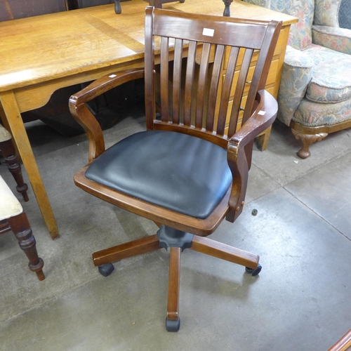 191 - A beech and black vinyl revolving desk chair