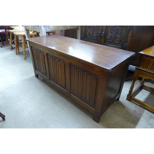 234 - A Jaycee carved oak credence cupboard and a carved oak linenfold blanket box