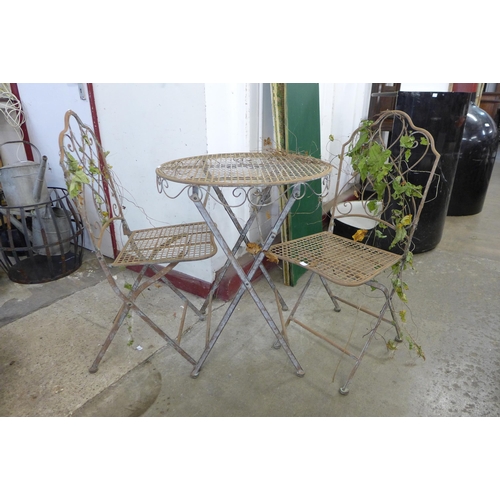 250 - A French style wrought alloy folding garden table and two chairs