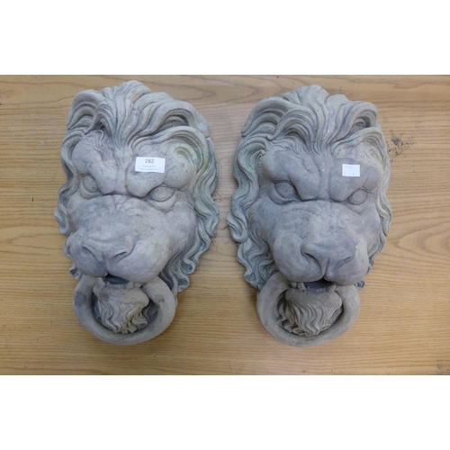 282 - A pair of concrete garden wall hanging lion masks