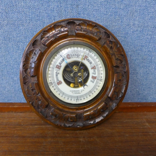 345 - An early 20th Century circular carved walnut aneroid barometer, the dial signed Chadburns Ltd., 47 C... 