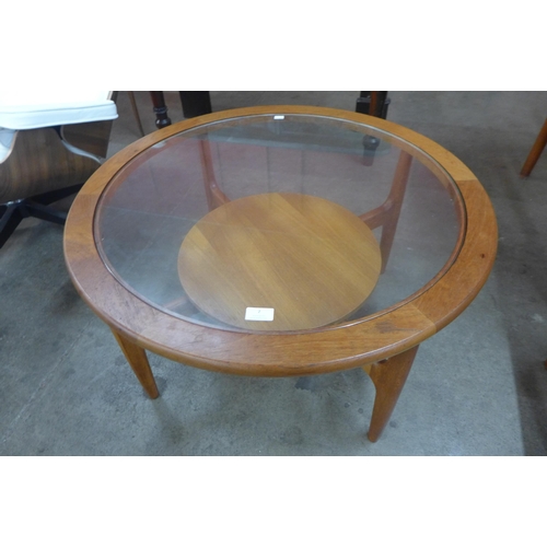 7 - A teak and glass topped circular coffee table