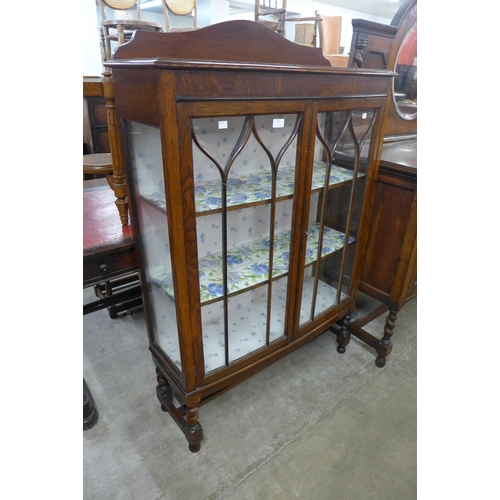 87 - An early 20th Century oak barleytwist bow front display cabinet