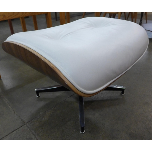 9 - A Charles & Ray Eames style simulated walnut and white leather revolving lounge chair and ottoman