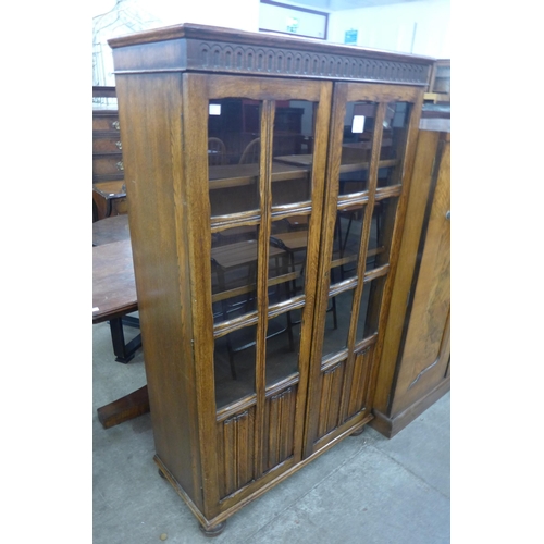 94 - A carved oak linenfold two door bookcase