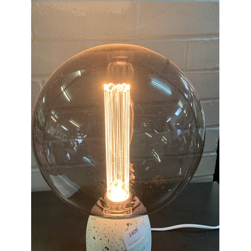 1350 - A terrazzo base table lamp with a large smoked glass anti-glare bulb featuring a decorative internal... 