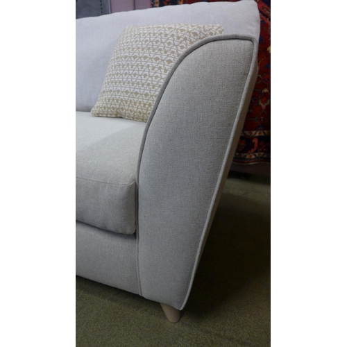 1373 - An oatmeal upholstered three seater sofa