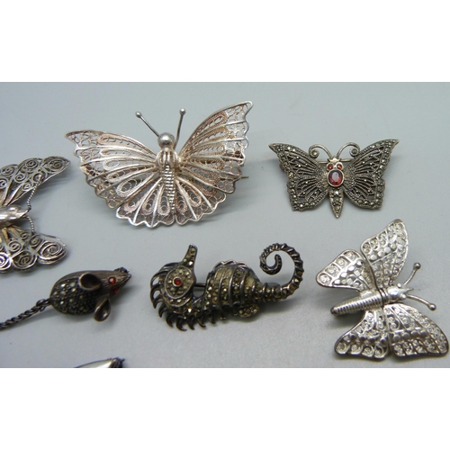 1063 - A collection of brooches including silver, filigree, butterflies, dragonfly, a mouse, etc.