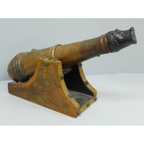 643 - A leather covered wooden decanter in the form of a cannon