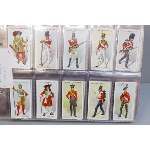 712C - Cigarette cards; an album of twelve complete sets of cigarette cards including Players Regimental Un... 