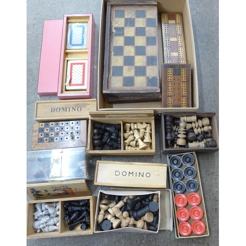 718 - A group of vintage chess pieces, dominoes, playing cards and draughts