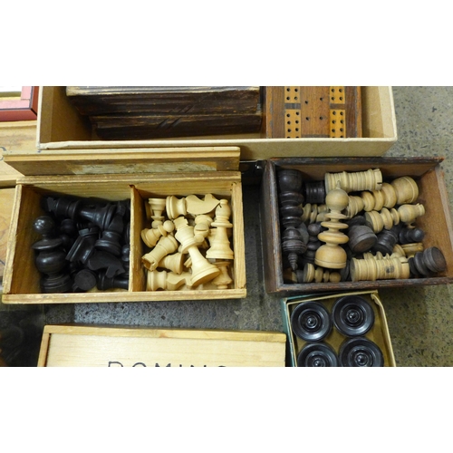 718 - A group of vintage chess pieces, dominoes, playing cards and draughts