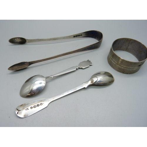 879 - A pair of silver sugar bows, a silver napkin ring, an early 19th Century silver mustard spoon and on... 