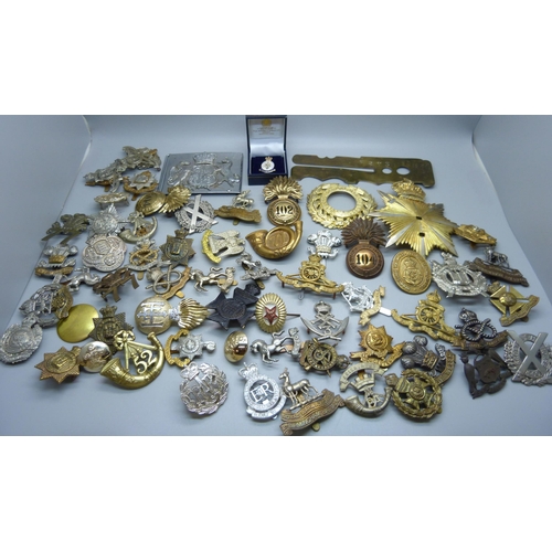 915 - A collection of British military cap badges, etc.