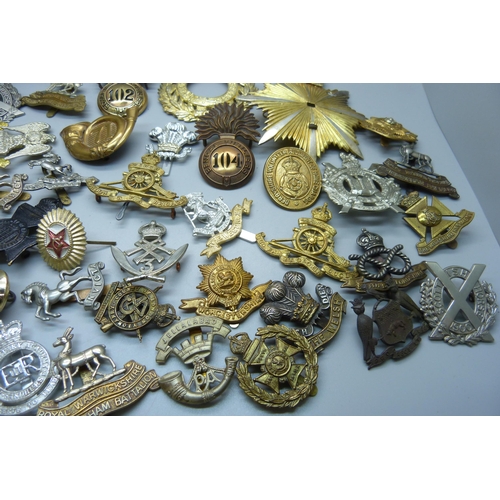 915 - A collection of British military cap badges, etc.