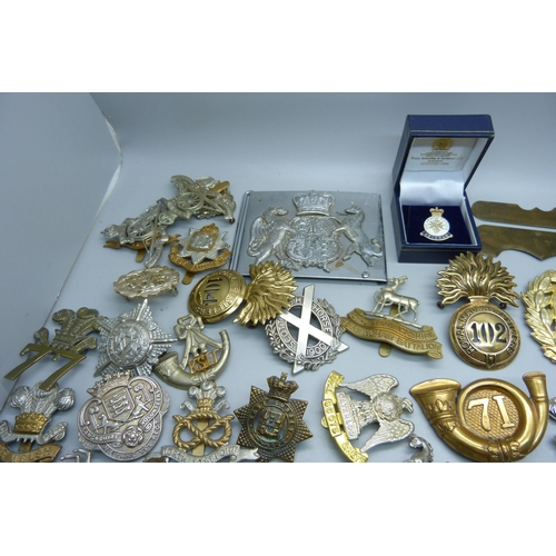 915 - A collection of British military cap badges, etc.