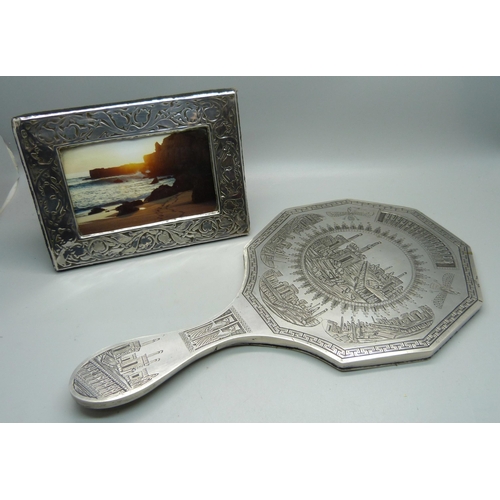 919 - A silver photograph frame, London 1985, 12cm x 16cm, and a hand mirror with engraved detail, Eastern... 