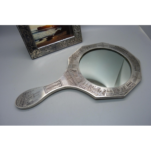 919 - A silver photograph frame, London 1985, 12cm x 16cm, and a hand mirror with engraved detail, Eastern... 