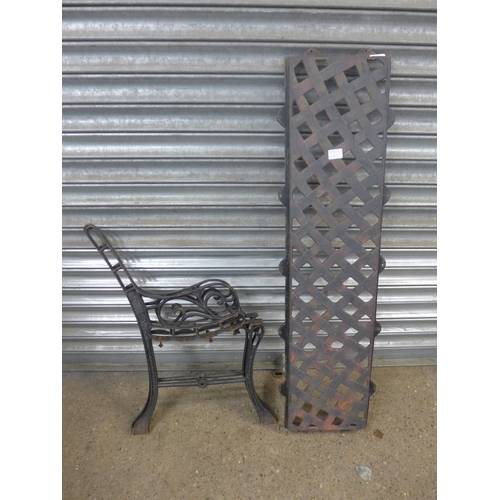 2258 - A pair of cast metal bench ends and a back plate