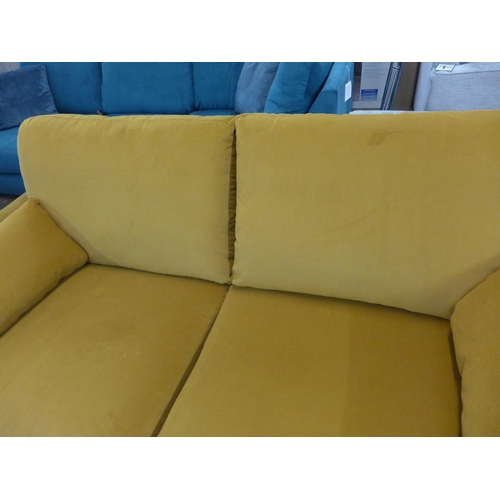 1407 - A turmeric velvet upholstered three seater sofa on dark oak legs
