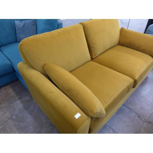 1407 - A turmeric velvet upholstered three seater sofa on dark oak legs