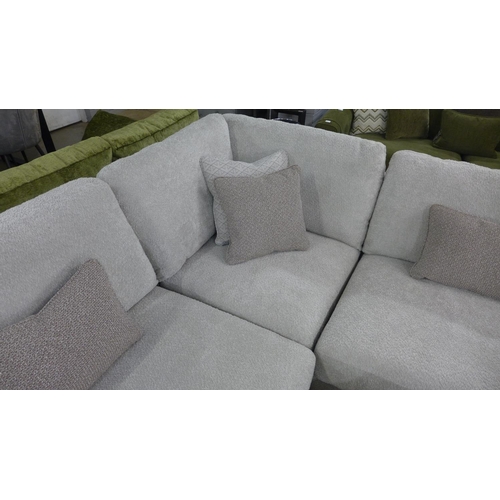 1452 - A grey fabric upholstered corner sofa with patterned scatter cushions RRP £6199