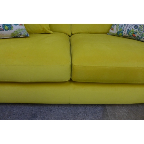 1459 - A mustard velvet upholstered three seater sofa with buttoned arms and zebra scatter cushions