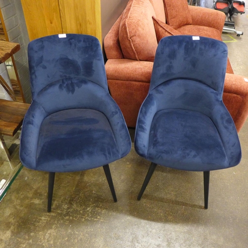 1496 - A pair of blue velvet upholstered dining chairs on black legs * this lot is subject to VAT