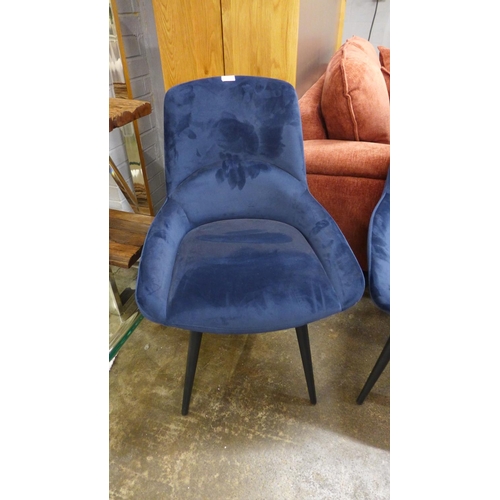 1496 - A pair of blue velvet upholstered dining chairs on black legs * this lot is subject to VAT