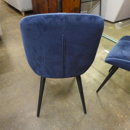 1496 - A pair of blue velvet upholstered dining chairs on black legs * this lot is subject to VAT