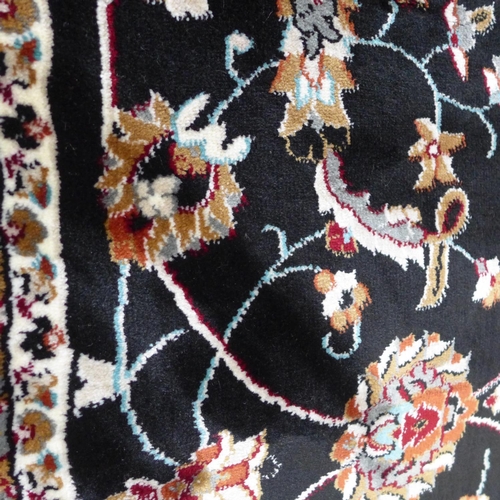 1519 - A black ground fine woven Iranian carpet with all over floral pattern