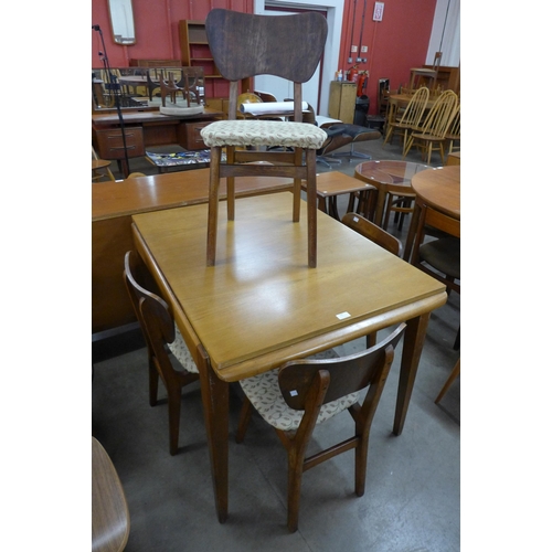 100 - A walnut extending dining table and four chairs