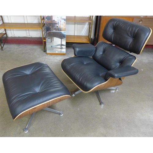 27 - A Charles & Ray Eames style simulated rosewood and black leather revolving lounge chair and ottoman