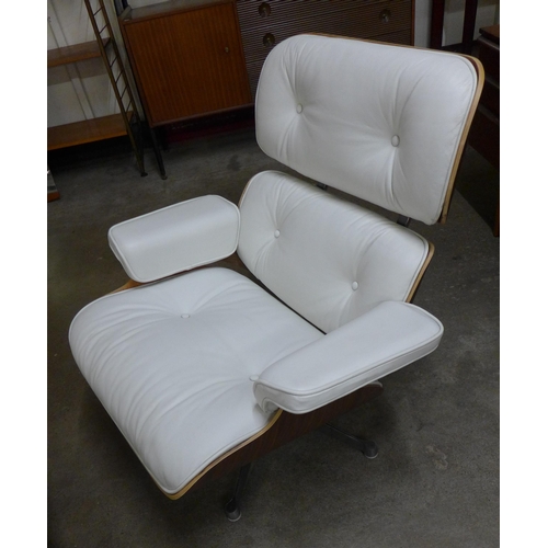 28 - A Charles & Ray Eames style simulated rosewood and white leather revolving lounge chair and ottoman