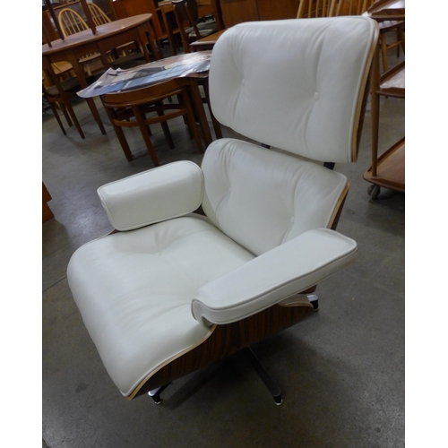 29 - A Charles & Ray Eames style simulated rosewood and white leather revolving lounge chair and ottoman