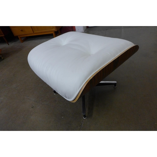 29 - A Charles & Ray Eames style simulated rosewood and white leather revolving lounge chair and ottoman