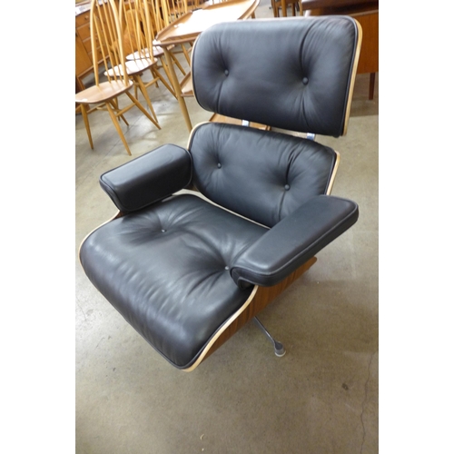 30 - A Charles & Ray Eames style simulated rosewood and black leather revolving lounge chair and ottoman