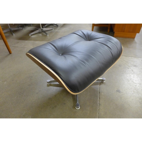 30 - A Charles & Ray Eames style simulated rosewood and black leather revolving lounge chair and ottoman