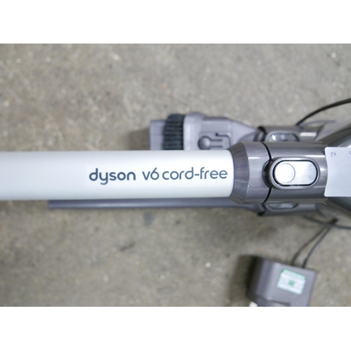 2184 - A Dyson V6 cordless stick vacuum cleaner with wall mount charger, unused battery and accessories