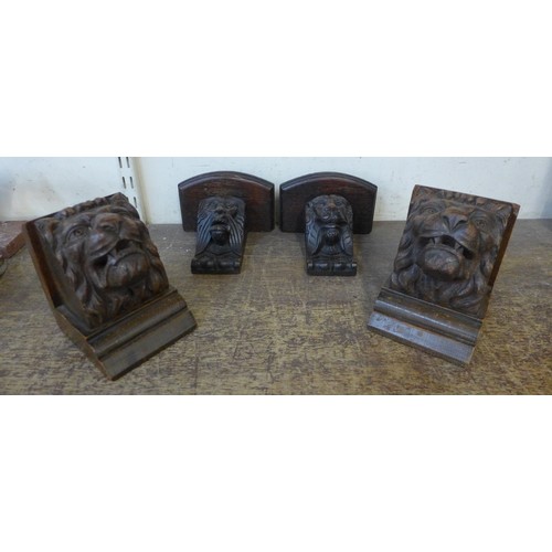 394 - A pair of small carved oak lion head bookends and a pair of carved oak wall shelves