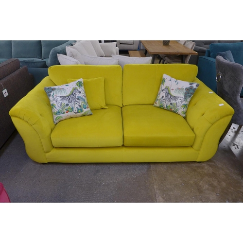 1325 - A mustard velvet upholstered three seater sofa with buttoned arms and zebra scatter cushions