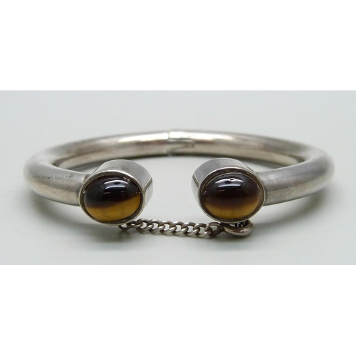 1005 - A white metal torque bangle set with two cabochon tigers eye stones, made by a silversmith in Derby ... 