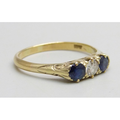 1021 - An 18ct gold, sapphire and diamond trilogy ring set with a central diamond and two sapphires, 2.5g, ... 