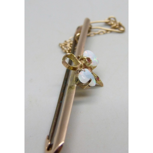 1023 - A 9ct gold bar brooch set with opals, one missing, 5cm, 3.5g