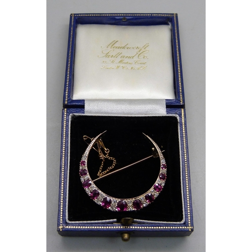 1026 - A yellow metal crescent brooch set with rubies and diamonds, 8g, 3.8cm