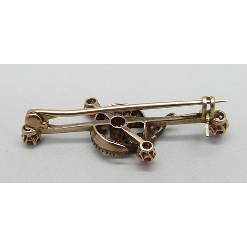 1040 - A yellow metal bar brooch with crescent design set with rubies and diamonds, 3.4g, 4cm, in associate... 